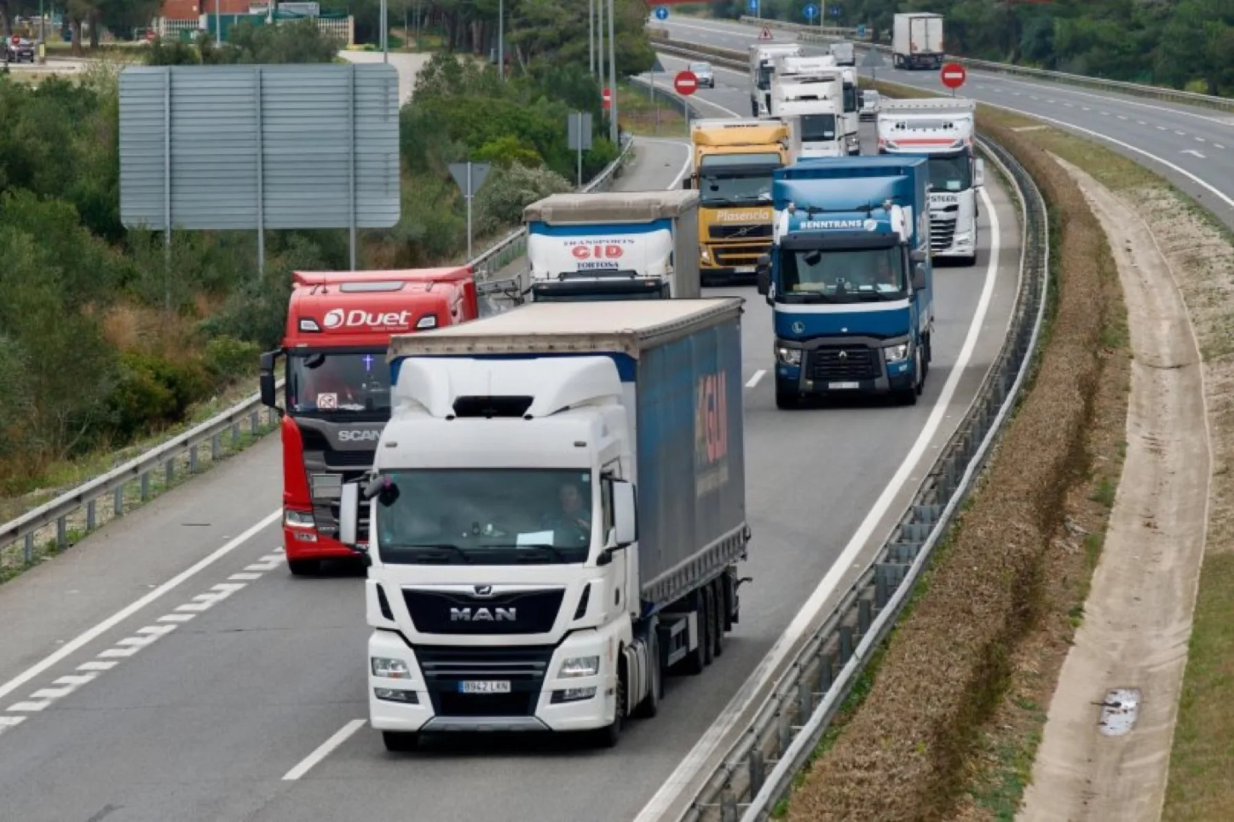 Flota de camiones circulando por una autopista